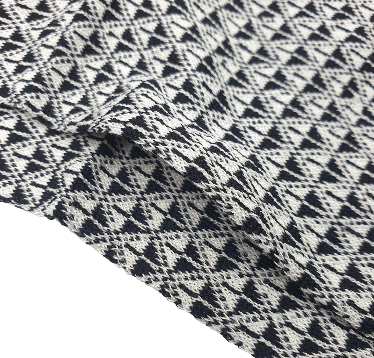 A close-up of a cotton sock with a black and off-white geometric pattern of interlocking triangles and diamonds, draped to show texture and folds.