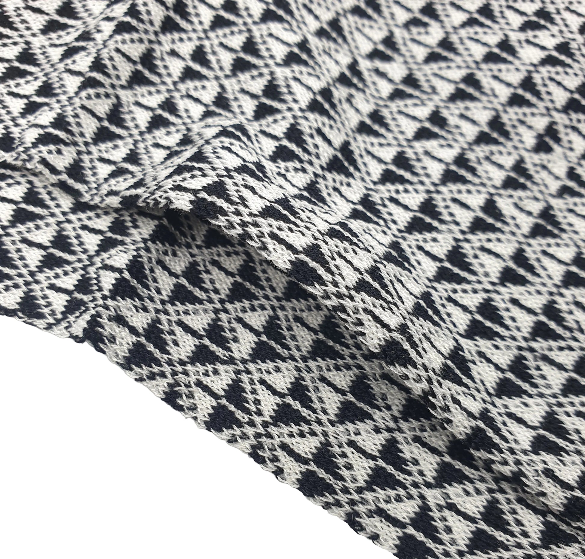 A close-up of a cotton sock with a black and off-white geometric pattern of interlocking triangles and diamonds, draped to show texture and folds.